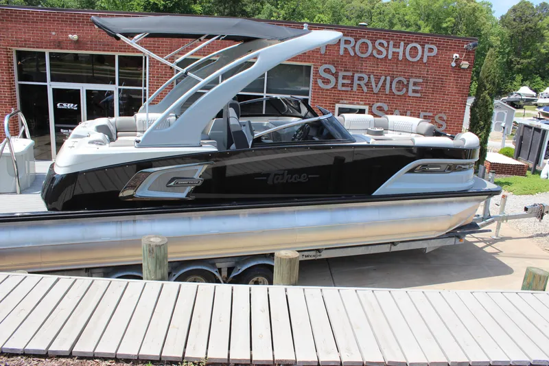 Slide: The Image of 2023 Tahoe Pontoon Grand Tahoe 25' boat displayed outside a service shop. - 3