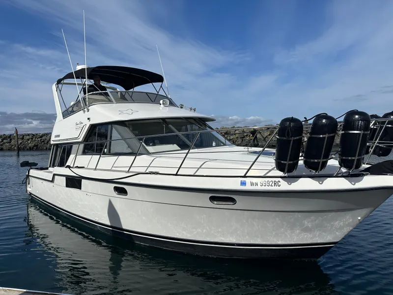 Slide: The Image of 1994 Carver 370 Voyager yacht docked in calm waters under a clear blue sky. - 2