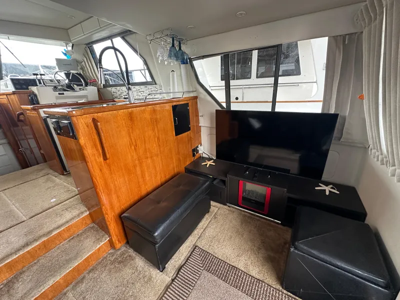 Slide: The Image of Interior of a 1994 Carver 370 Voyager yacht with modern furnishings and entertainment setup. - 25