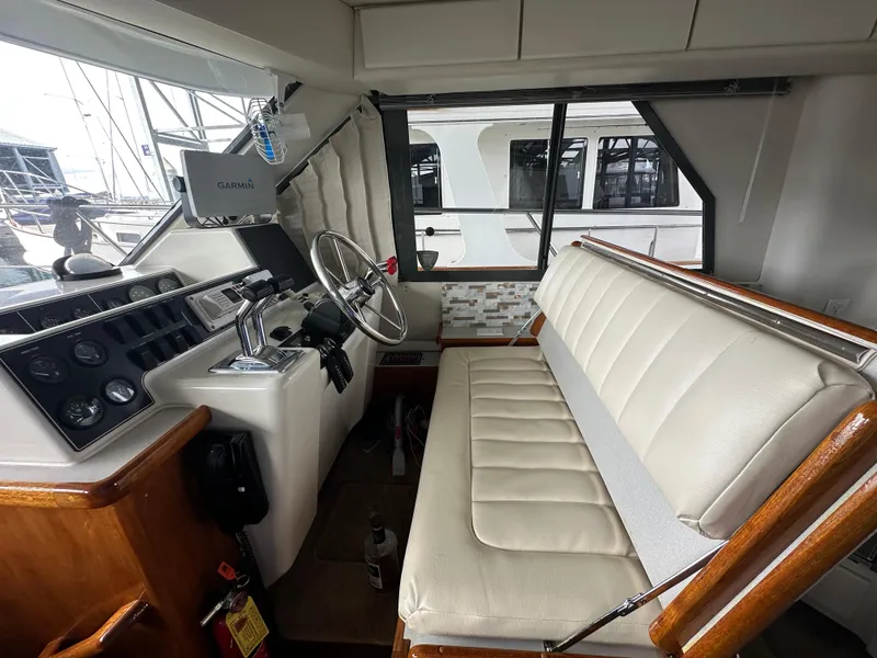 Slide: The Image of Interior of 1994 Carver 370 Voyager boat with helm, steering wheel, and cushioned seating. - 35