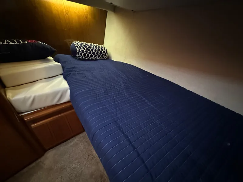 Slide: The Image of 1994 Carver 370 Voyager cabin with blue bedding and pillows. - 37