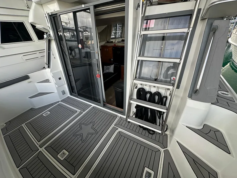 Slide: The Image of 1994 Carver 370 Voyager yacht deck with sliding glass door and ladder. - 8