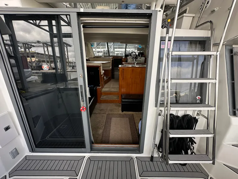 Slide: The Image of 1994 Carver 370 Voyager yacht interior with sliding glass door and ladder, showcasing elegant design. - 9