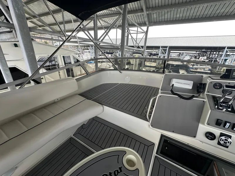 Slide: The Image of 1994 Carver 370 Voyager yacht cockpit with seating and control panel in a marina setting. - 12