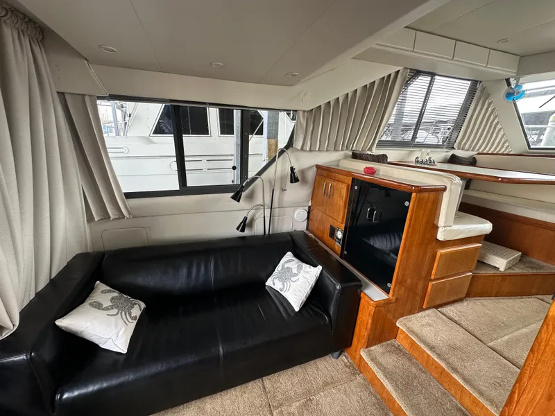 Slide: The Image of Interior of 1994 Carver 370 Voyager yacht with black sofa and wooden cabinetry. - 23