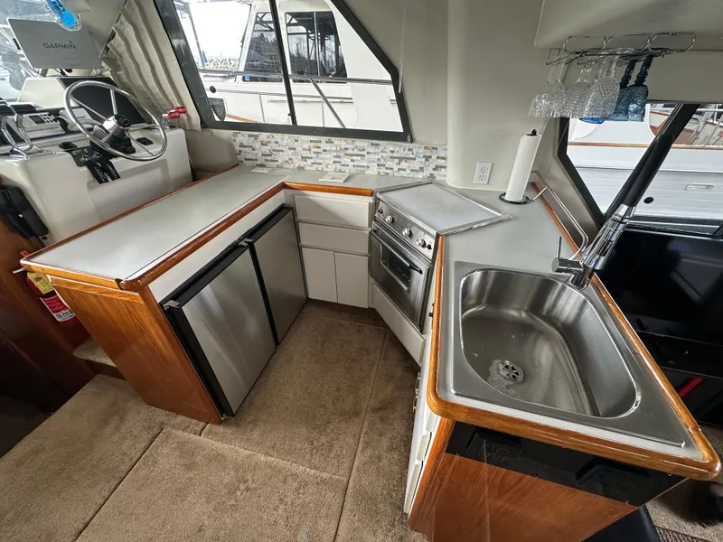 Slide: The Image of 1994 Carver 370 Voyager yacht kitchen with stainless steel sink, compact appliances, and modern backsplash. - 30