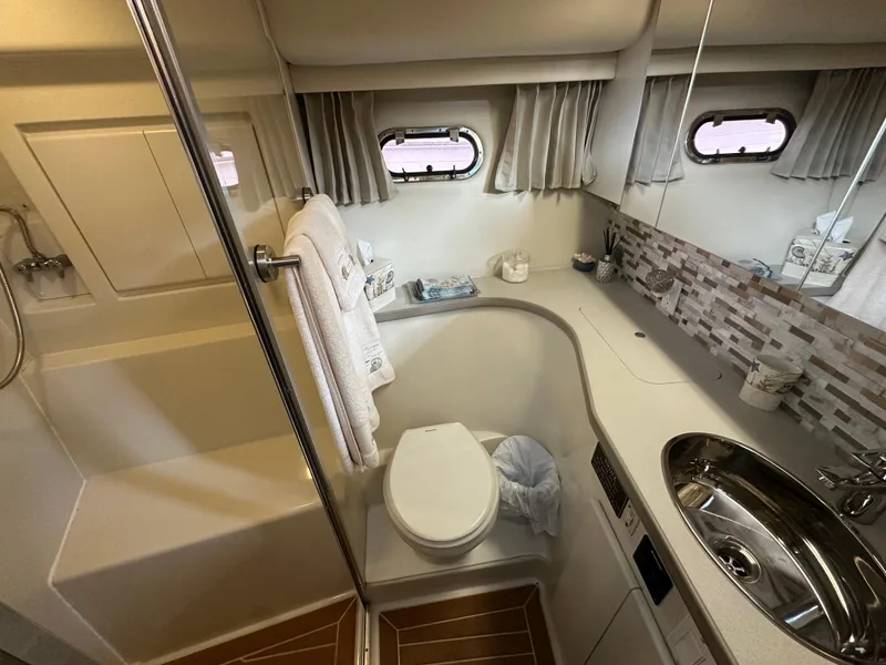 Slide: The Image of 1994 Carver 370 Voyager bathroom with shower, sink, and porthole windows. - 39