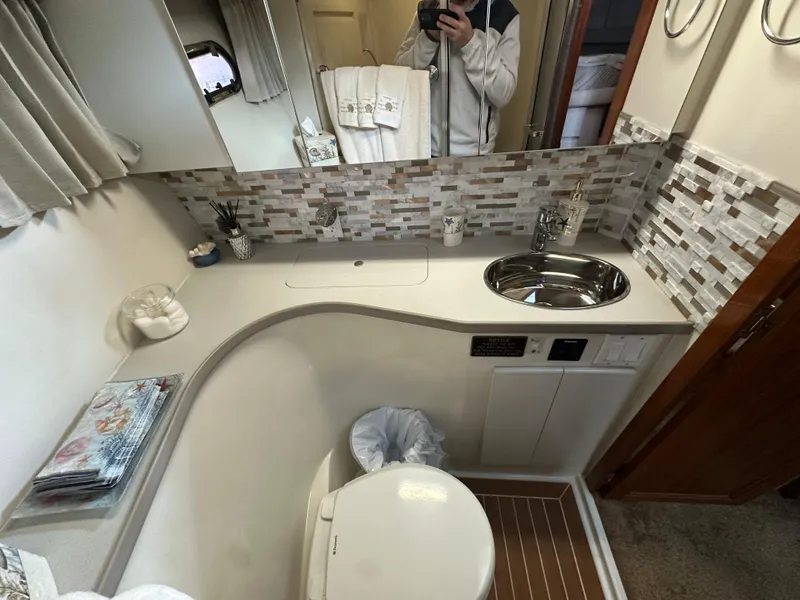 Slide: The Image of Bathroom interior of a 1994 Carver 370 Voyager yacht, featuring modern fixtures and mosaic backsplash. - 41