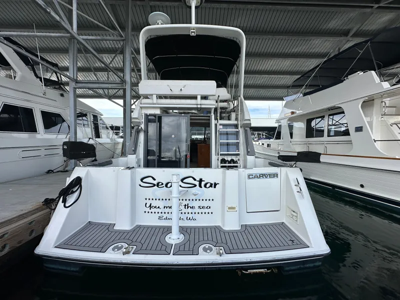 Slide: The Image of 1994 Carver 370 Voyager docked, rear view, with "Sea Star" name on the stern. - 5