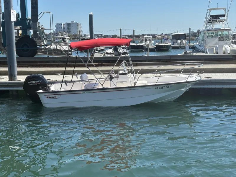 Slide: The Image of 2004 Boston Whaler 170 Montauk boat with red canopy docked at marina. - 16