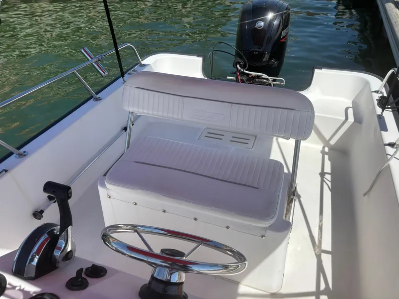 Slide: The Image of 2004 Boston Whaler 170 Montauk boat interior with steering wheel and seating. - 2
