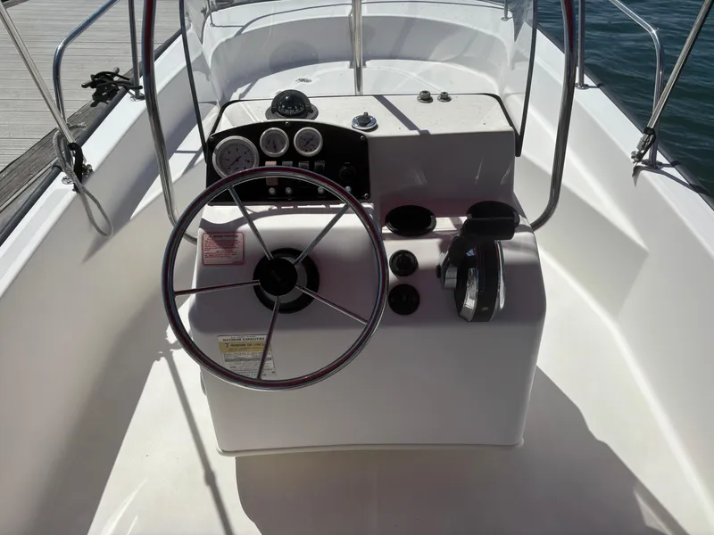 Slide: The Image of 2004 Boston Whaler 170 Montauk boat console with steering wheel and controls. - 8