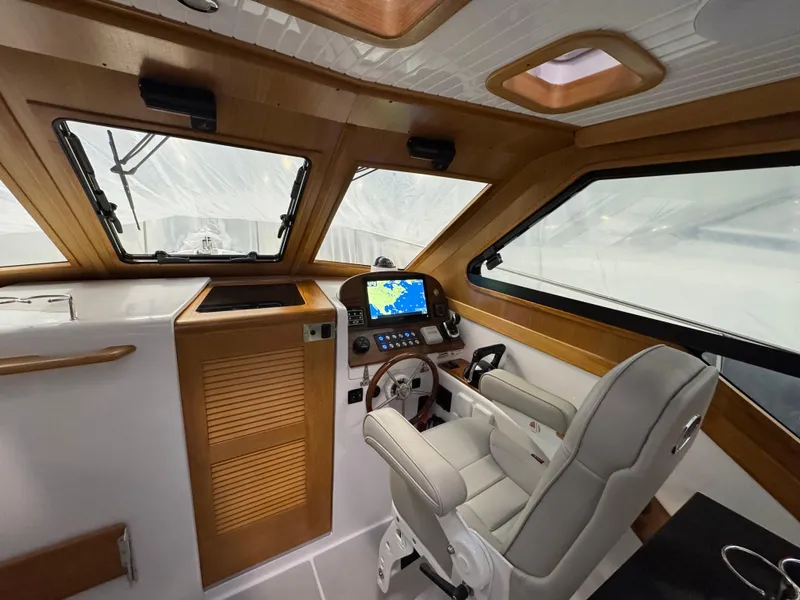Slide: The Image of 2022 True North 34 Outboard Express boat interior with helm, navigation system, and captain's chair. - 11