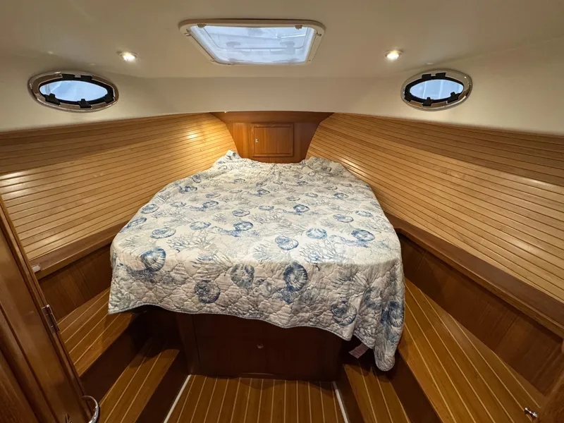 Slide: The Image of 2022 True North 34 Outboard Express cabin with cozy bed and wooden interior. - 17