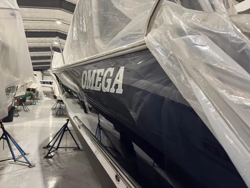 Slide: The Image of 2022 True North 34 Outboard Express boat named "Omega" covered in protective plastic. - 23