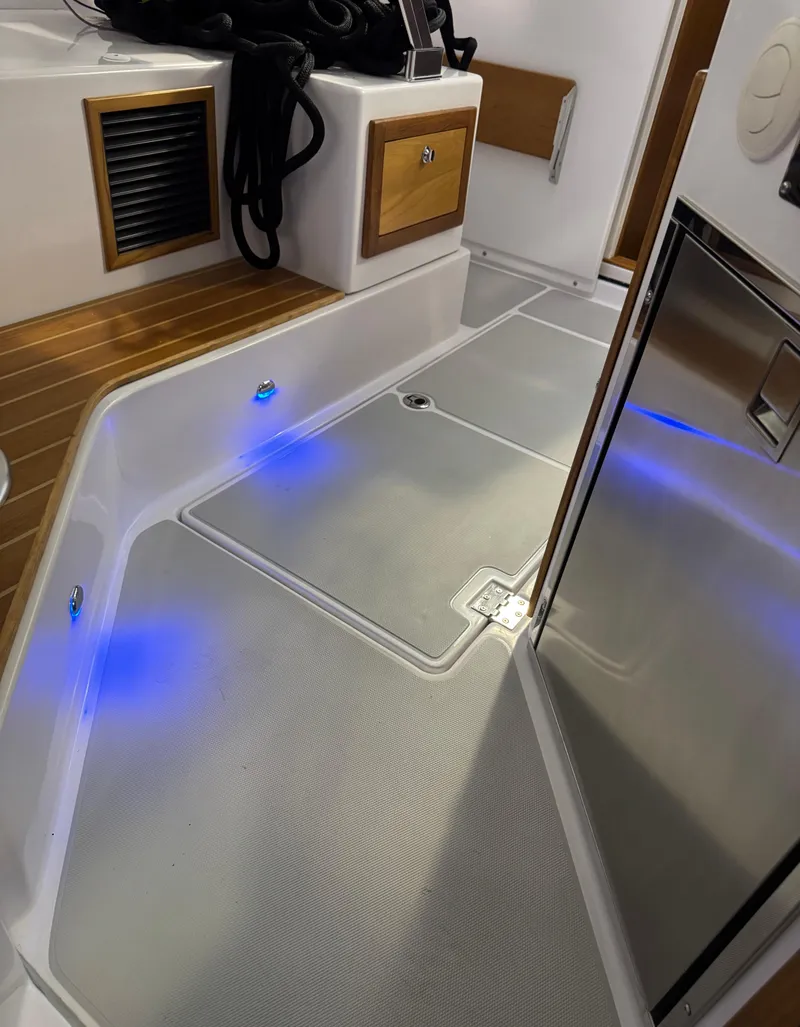 Slide: The Image of 2022 True North 34 Outboard Express interior with modern flooring and ambient blue lighting. - 5