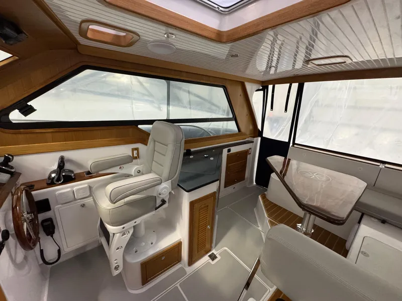 Slide: The Image of 2022 True North 34 Outboard Express interior with helm, seating, and wooden accents. - 8