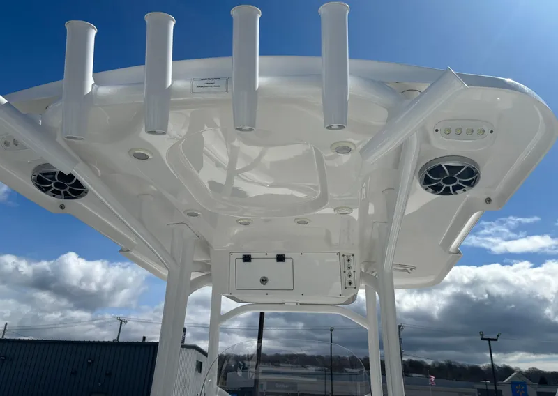 Slide: The Image of 2021 Sea Pro 219 Center Console boat with rod holders and speakers under a clear sky. - 13