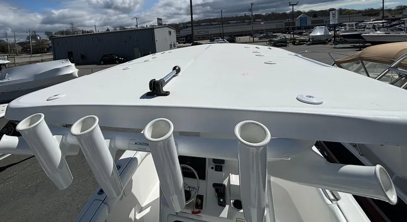 Slide: The Image of 2021 Sea Pro 219 Center Console boat with rod holders and T-top, parked outdoors. - 14