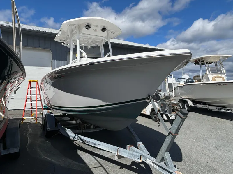 Slide: The Image of 2021 Sea Pro 219 Center Console boat on trailer, parked outdoors under a cloudy sky. - 2