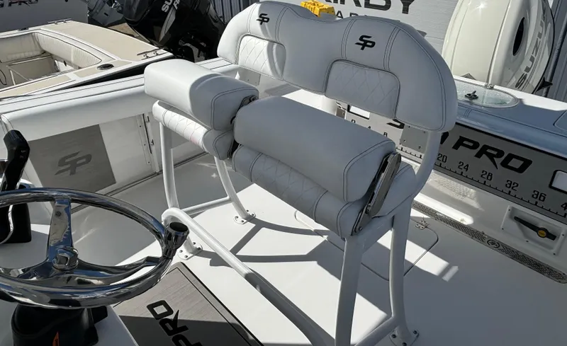 Slide: The Image of 2021 Sea Pro 219 Center Console boat with white seating and steering wheel. - 6