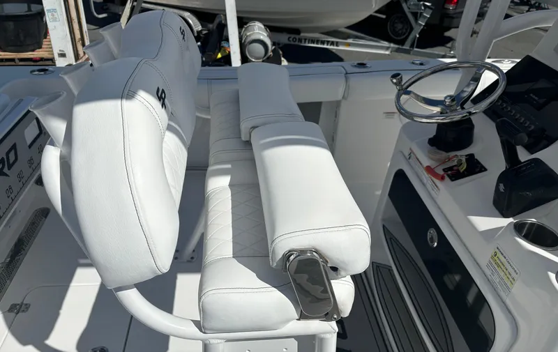 Slide: The Image of 2021 Sea Pro 219 Center Console boat interior with white seating and steering wheel. - 7