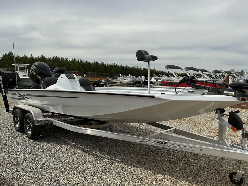 Slide: The Image of 2025 Xpress Hyper-Lift Bass Series boat on trailer, parked on gravel lot. - 1