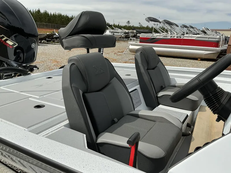 Slide: The Image of 2025 Xpress Hyper-Lift Bass Series boat interior with gray seats and steering wheel. - 8