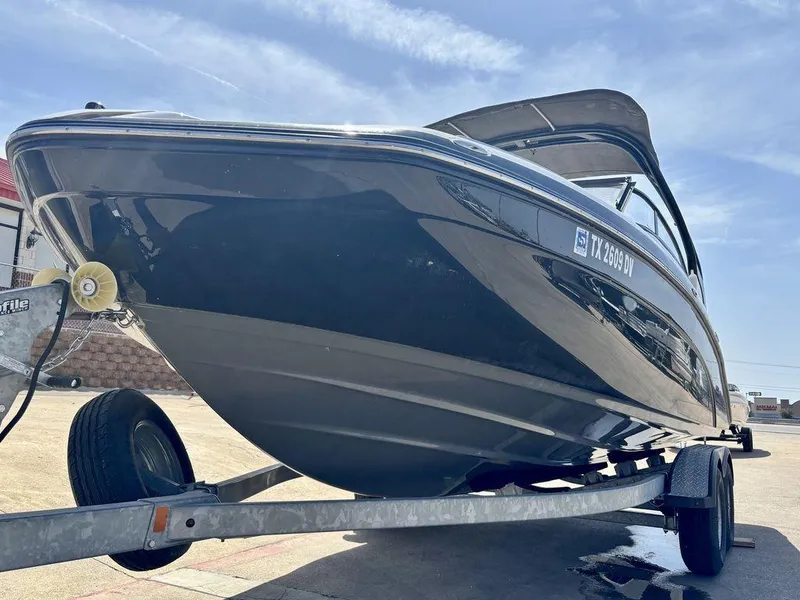 Slide: The Image of 2017 Yamaha Boats 212 Limited S on trailer, sleek design under clear sky. - 2