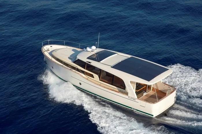 Slide: The Image of 2022 Greenline 40 Hybrid yacht cruising on open water, showcasing sleek design and solar panels. - 0