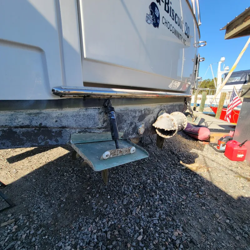Slide: The Image of 2022 Greenline 40 Hybrid boat stern view on gravel, showcasing trim tabs and exhaust. - 19