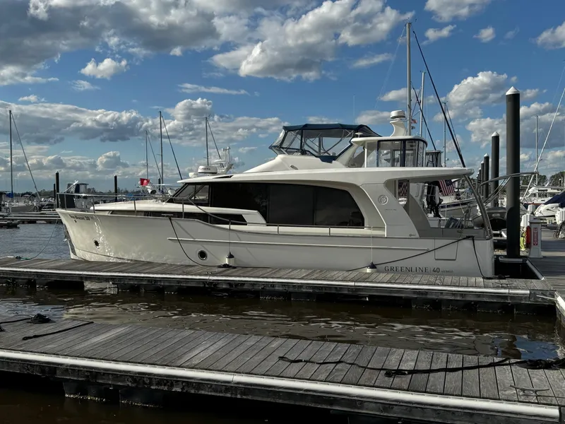 Slide: The Image of 2022 Greenline 40 Hybrid yacht docked at marina under blue sky with clouds. - 2