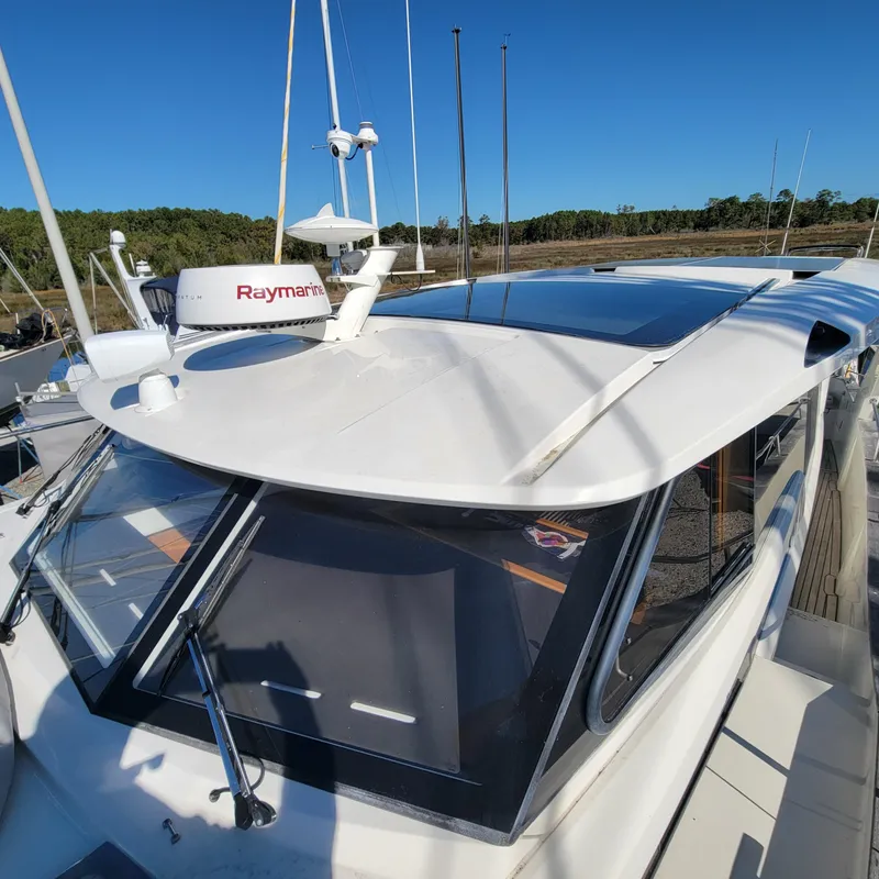 Slide: The Image of 2022 Greenline 40 Hybrid yacht with Raymarine equipment, docked under clear blue sky. - 28