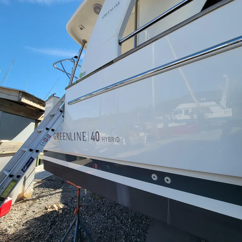 Slide: The Image of 2022 Greenline 40 Hybrid yacht on dry dock with ladder, clear sky background. - 5