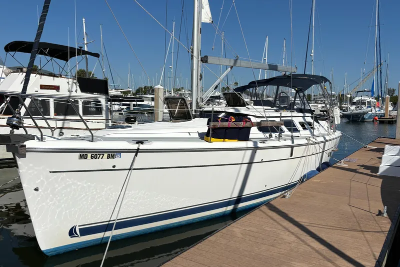 Slide: The Image of 2005 Hunter 41 Deck Salon sailboat docked at marina under clear blue sky. - 1