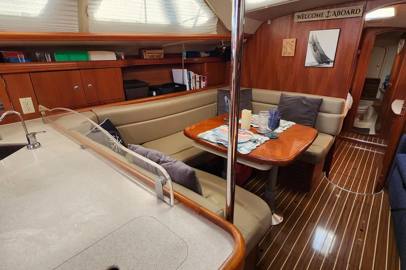 Slide: The Image of 2005 Hunter 41 Deck Salon interior with cozy seating, dining table, and elegant wood finish. - 18