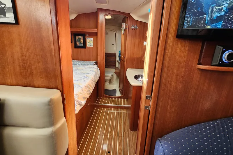 Slide: The Image of Interior of 2005 Hunter 41 Deck Salon yacht, featuring wood paneling and cozy cabin layout. - 21