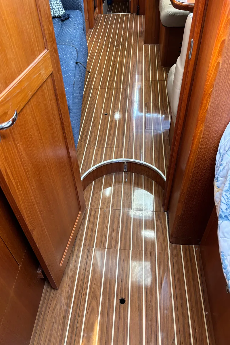 Slide: The Image of Interior view of 2005 Hunter 41 Deck Salon with polished wooden flooring. - 25