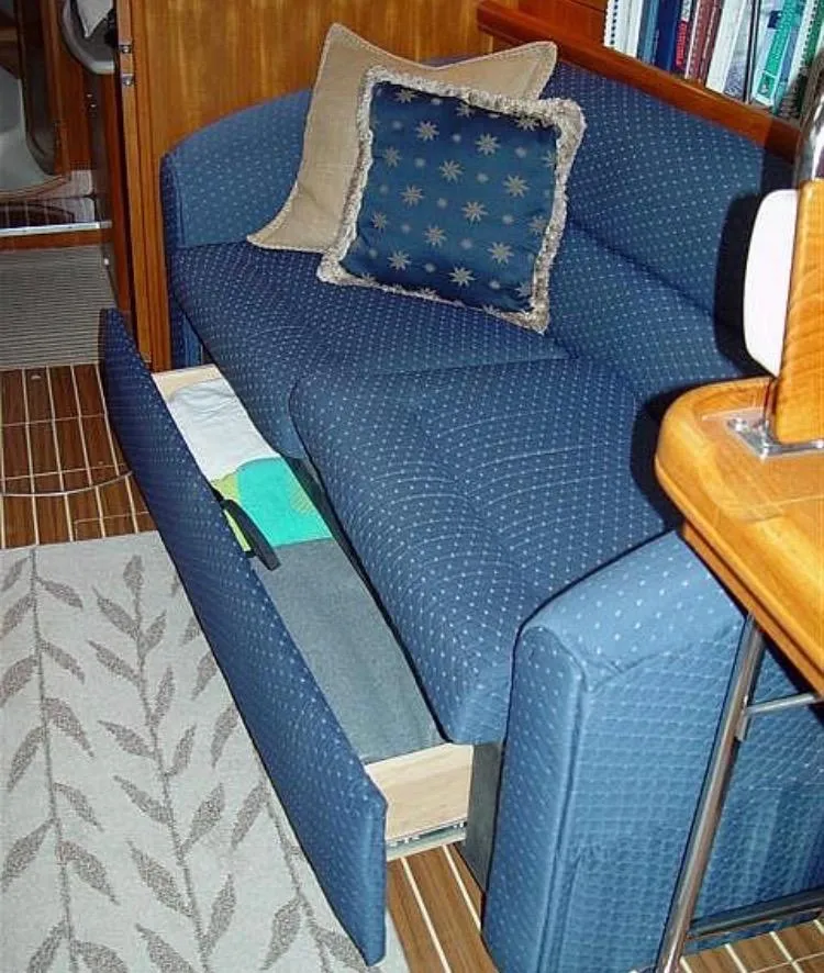 Slide: The Image of 2005 Hunter 41 Deck Salon interior with blue sofa and storage drawer open. - 29