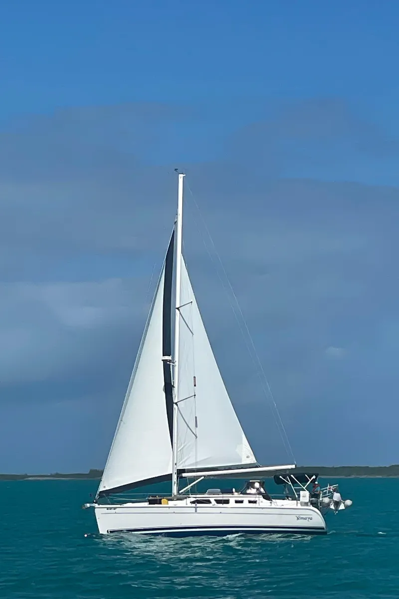 Slide: The Image of 2005 Hunter 41 Deck Salon sailboat cruising on turquoise waters under a clear blue sky. - 3
