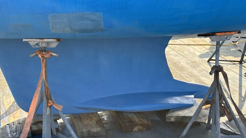 Slide: The Image of 2005 Hunter 41 Deck Salon sailboat keel on stands, blue hull, outdoor setting. - 37