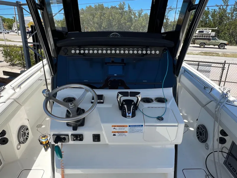 Slide: The Image of 2024 World Cat 260 CC-X boat cockpit with steering wheel and controls. - 18