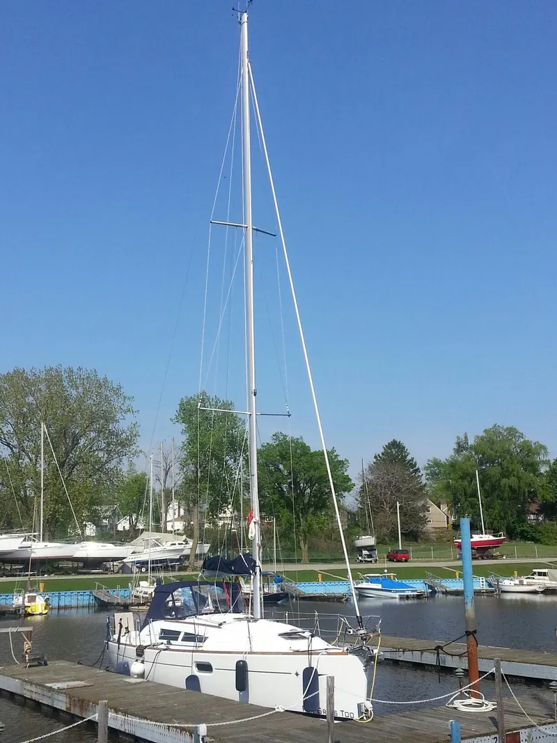 Slide: The Image of 2010 Jeanneau Sun Odyssey 36i sailboat docked in a marina under clear blue sky. - 1