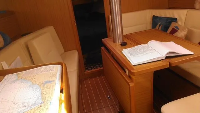 Slide: The Image of Interior of 2010 Jeanneau Sun Odyssey 36i sailboat with navigation charts and open book. - 17