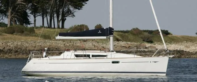 Slide: The Image of 2010 Jeanneau Sun Odyssey 36i sailboat on calm water near a wooded shoreline. - 18