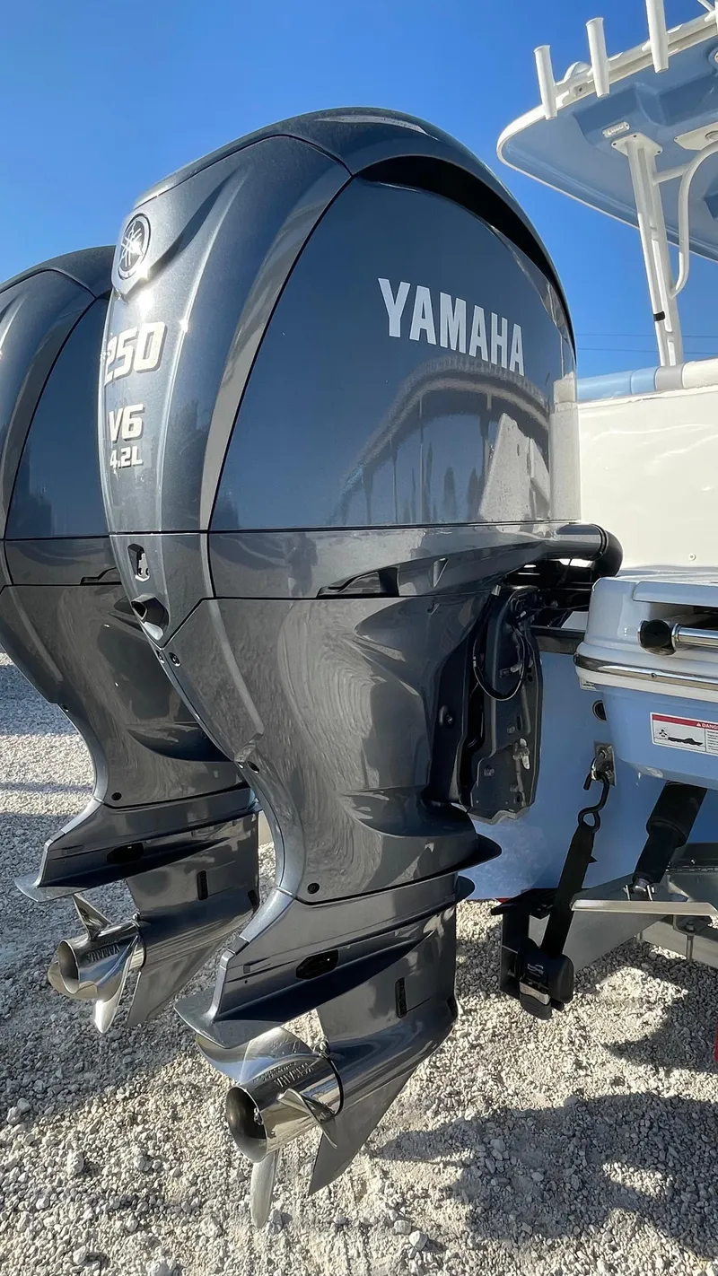 Slide: The Image of 2023 Robalo R272 Center Console with Yamaha V6 outboard engines, parked on gravel. - 15