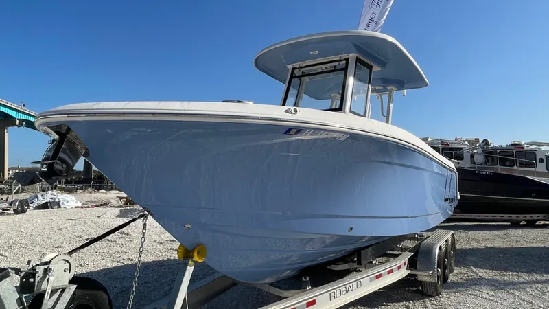 Slide: The Image of 2023 Robalo R272 Center Console boat on trailer, displayed outdoors. - 2