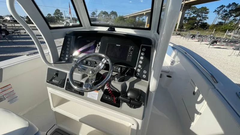 Slide: The Image of 2023 Robalo R272 Center Console boat dashboard with steering wheel and controls. - 24