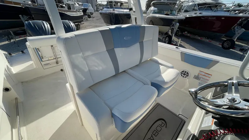 Slide: The Image of 2023 Robalo R272 Center Console boat interior with cushioned seating and steering wheel. - 26