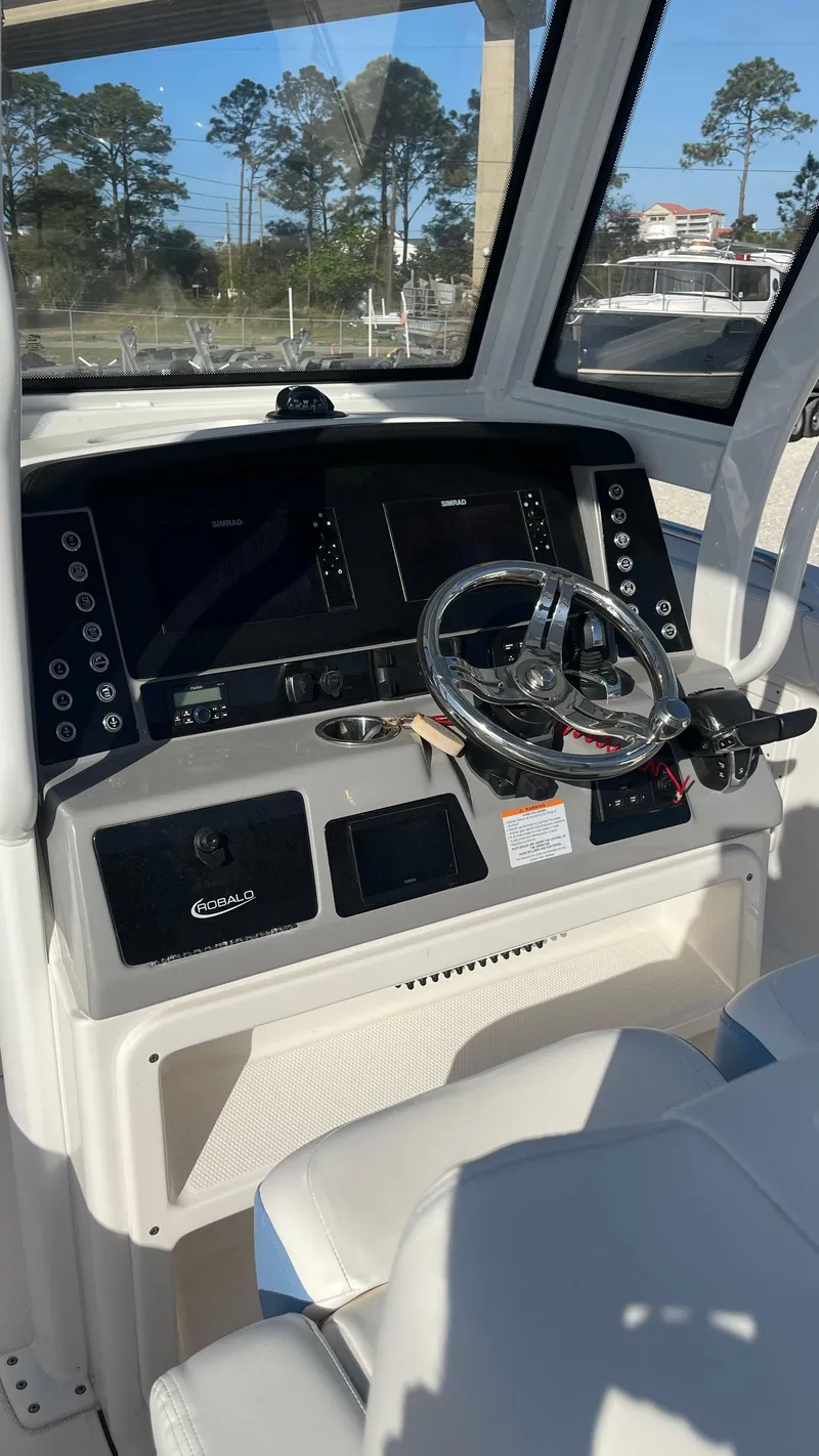 Slide: The Image of 2023 Robalo R272 Center Console boat dashboard with steering wheel and controls. - 36